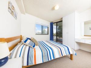 a white bedroom with a bed and a window at Centrepoint 10 in Forster