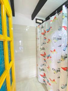 a bathroom with a shower curtain with fish on it at Hostal Portal Del Sol in Capurganá