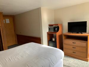 a hotel room with a bed and a flat screen tv at Belle Aire Motel - Downtown Convention Center - Gatlinburg in Gatlinburg