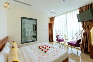 um quarto de hotel com uma cama com rosas numa mesa em Thọ Hướng Hotel - Phan Thiết em Phan Thiet