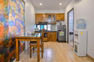 a kitchen with a wooden table and a refrigerator at 22housing Cau Giay Hotel & Residence in Hanoi