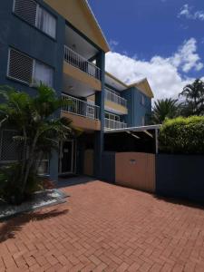 a large apartment building with a brick driveway at Homely Inn Hostel in Gold Coast