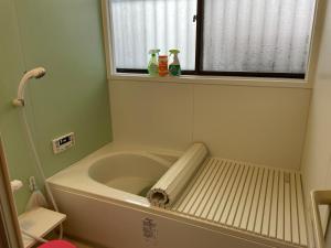 a bath tub in a bathroom with a window at kyoka house練馬 in Tokyo