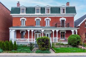 una gran casa de ladrillo rojo con techo verde en Centennial 6-Bedroom Waterfront Palace Sleeps 14, en Montreal