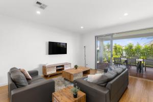 a living room with two couches and a table at Western Breeze in Port Willunga