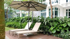 a pair of chairs and an umbrella on a patio at Starwarzz Medini 1 Legoland in Nusajaya