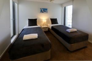 2 camas en una habitación con ventanas en Space Holiday Apartments, en Maroochydore