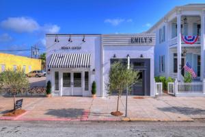 a white building with a sign for a music store at The Palms Room At Emilys On The Island in Galveston