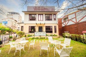 une cour avec des chaises et des tables blanches en face d'une maison dans l'établissement Moonlake B&B, à Yuchi