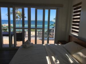 ein Schlafzimmer mit Bett und Meerblick in der Unterkunft Maykenn Beach-Cafe-Bar and Restaurant in Ocoy