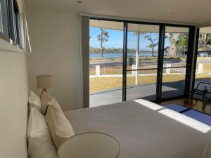 a bedroom with a bed and a view of the ocean at Gull Apartment in Strahan