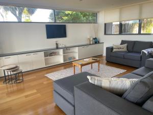 a living room with a couch and a tv at Gull Apartment in Strahan +9 photos
