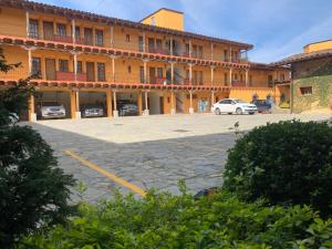 duży budynek z samochodami zaparkowanymi na parkingu w obiekcie Hotel Posada Don Ramon w mieście Zacatlán