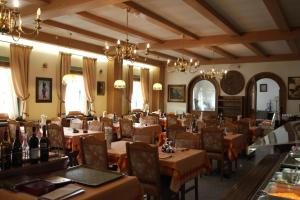 un comedor con mesas, sillas y lámparas de araña en Hotel Genziana en Passo Stelvio