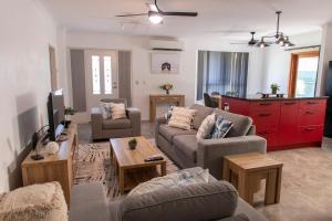 a living room with two couches and a red cabinet at Meraki Villa in Marcoola