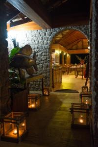 a room with a stone wall and a table with lights at Colibri Hotel in Baie Sainte Anne
