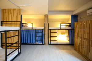 a room with four bunk beds and a hallway at Ganse Guesthouse in Jeju