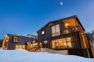 un edificio nero con la neve davanti di Bristol Hotel and Spa Bakuriani a Bakuriani
