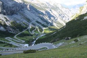 a winding mountain road in the mountains with a highway at Hotel Genziana in Passo Stelvio