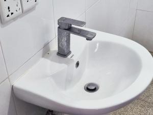a white sink with a metal faucet in a bathroom at Schatzi's Hideaway in Tangalle +94 photos