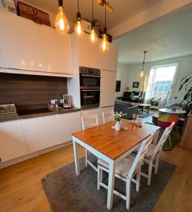 a kitchen and dining room with a wooden table and chairs at Spacious and cozy apartment in the heart of Haddington in Haddington