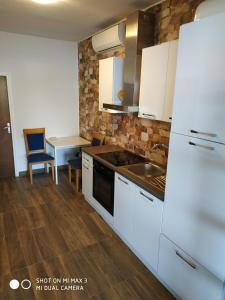 eine Küche mit weißen Geräten und einem Tisch mit Stühlen in der Unterkunft Apartment ZAGLAV 1 in Zaglav