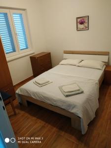 a bedroom with a bed with two towels on it at Apartment ZAGLAV 1 in Zaglav