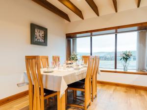 a dining room with a table and chairs and a window at The Middle Byre in Girthon