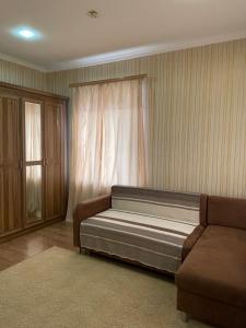エッセントゥキにあるGuest House Nataliのソファと窓が備わるドミトリールームのベッド1台分です。
