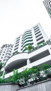 曼谷的住宿－黃絲帶山精品套房公寓，前面有树木的白色大建筑