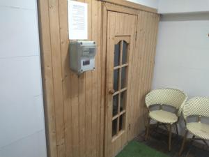 a room with a wooden wall with a tv and chairs at BenGurion 25 Apartment in Haifa