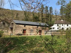 a stone house with a black roof at Red Deer Cottage in Minehead