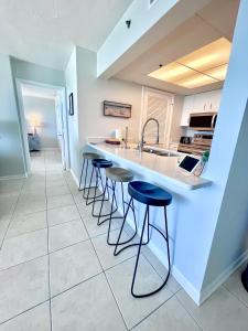 a kitchen with stools at a counter and a sink at Emerald Bay Escape in Panama City Beach