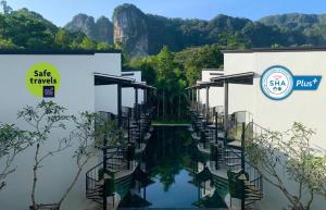 a pool of water in front of two buildings at Anana Ecological Resort Krabi-SHA Extra Plus in Ao Nang Beach