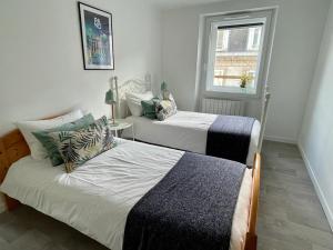 モルレーにあるLes Appartements de Viarmes et de Guernisacの窓のある部屋にツインベッドが2台