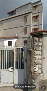 a white building with a gate in front of it at Civico85 in Naples