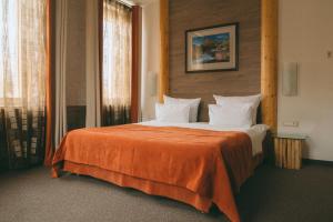 a bedroom with a large bed with an orange blanket at Alpen Club in Sheregesh