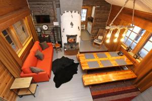vistas panorámicas a una sala de estar con muebles de color naranja en Kuukkeli Log Houses Aurora Cabin - Jaspis en Saariselka