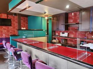 a kitchen with red and green cabinets and purple chairs at Naoshima Kowloon in Naoshima