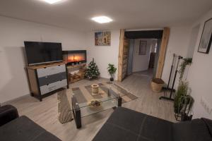 uma sala de estar com televisão e uma árvore de Natal em MBL Apartman Winter em Rezi