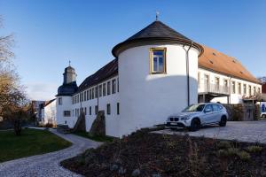 a car parked in front of a white building at homie stay am Schloss Apartments in Würzburg