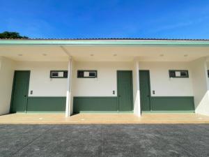 - un grand bâtiment avec des portes et des fenêtres vertes dans l'établissement Sky View Resort Buriram, à Buriram