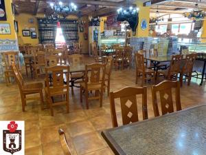 um restaurante com mesas e cadeiras num quarto em Hotel Flor de la Mancha em La Roda