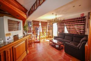 uma sala de estar com um sofá e uma televisão em Hotel Flor de la Mancha em La Roda