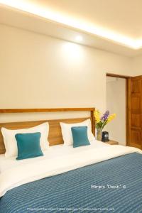 a bedroom with a large bed with blue pillows at Mirje's Deck - Homestay - Family Rooms in Kolhapur