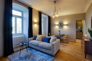 a living room with a couch and a table at Grimm's Schlossapartments Würzburg - by homekeepers in Würzburg