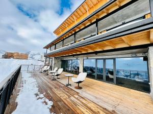 a row of wooden benches sitting on top of a snow covered beach at Monte Hotel in Gudauri