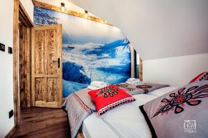 2 Betten in einem Zimmer mit Wandgemälde in der Unterkunft Laura Resort - Luxury Chalets z jacuzzi in Szaflary