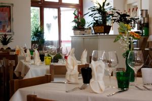 een restaurant met tafels met witte tafelkleden en wijnglazen bij Paneolio Food and Drink B&B in Poggio Picenze