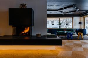 sala de estar con chimenea y sofá en Appart Hotel Knappaboda, en Lech am Arlberg